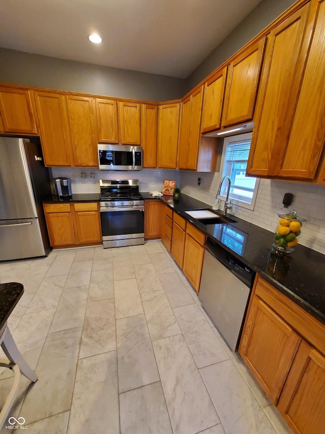 kitchen featuring backsplash, stainless steel appliances, sink, and dark stone countertops