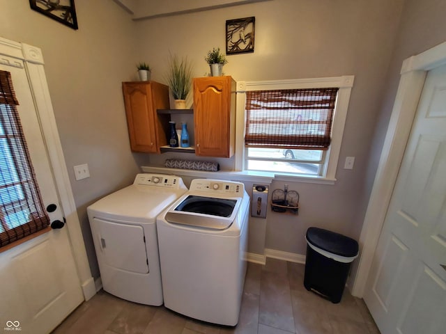 laundry area featuring cabinets, light tile patterned floors, and washer and dryer