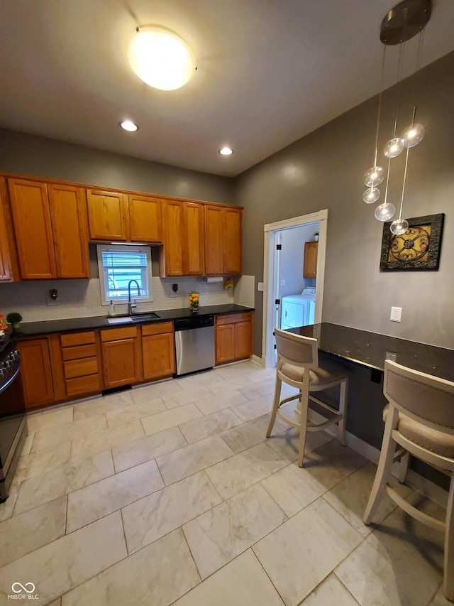 kitchen featuring pendant lighting, separate washer and dryer, sink, stove, and stainless steel dishwasher