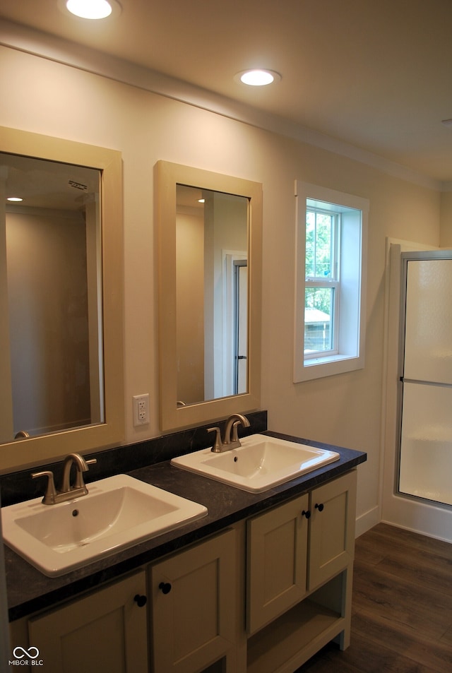 bathroom featuring walk in shower, dual vanity, and hardwood / wood-style floors