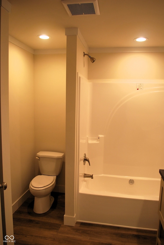 full bathroom with washtub / shower combination, wood-type flooring, vanity, and toilet