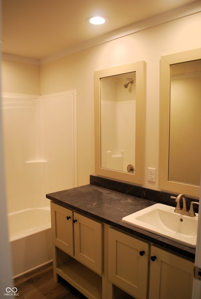 bathroom featuring shower / bathtub combination, vanity, and wood-type flooring