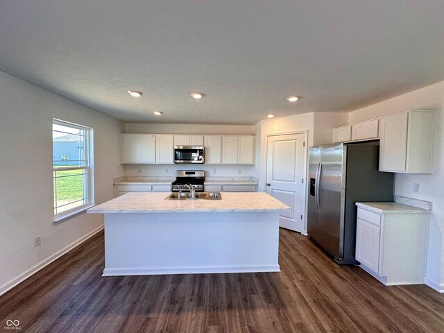1126 Fleming Dr, Greenfield, IN 46140 - kitchen with an island with sink, stainless steel appliances, white cabinets, baseboards, and dark wood-type flooring