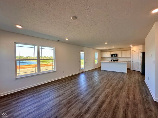 1126 Fleming Dr, Greenfield, IN 46140 - unfurnished living room with recessed lighting, dark wood finished floors, and a textured ceiling