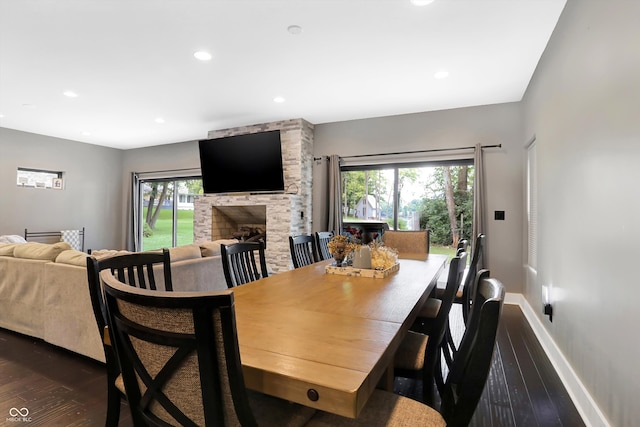 dining space with dark hardwood / wood-style flooring, a fireplace, and plenty of natural light