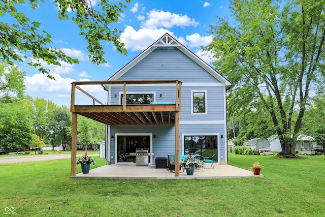 back of property with a balcony, a patio area, and a yard