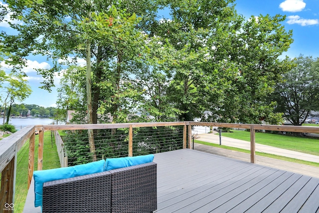 wooden deck with a lawn, a water view, and outdoor lounge area