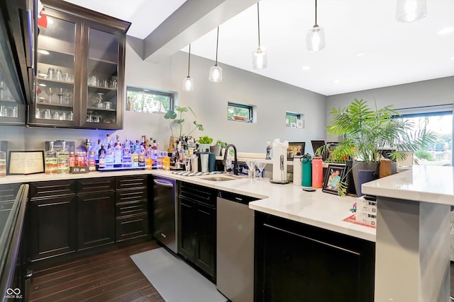 kitchen with dark hardwood / wood-style floors, dark brown cabinetry, sink, decorative light fixtures, and kitchen peninsula