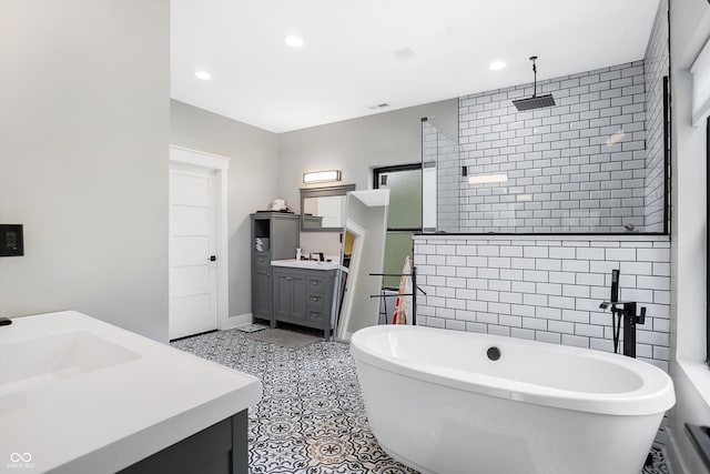 bathroom with tile patterned flooring, vanity, and a tub to relax in