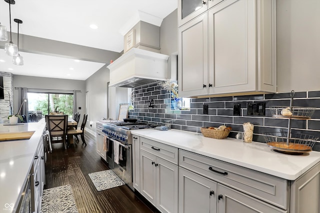 kitchen with backsplash, dark wood-type flooring, pendant lighting, custom range hood, and range with two ovens