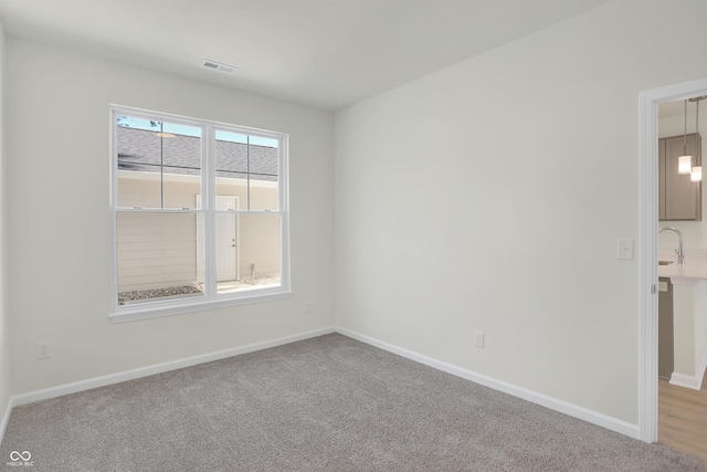 unfurnished room with light carpet