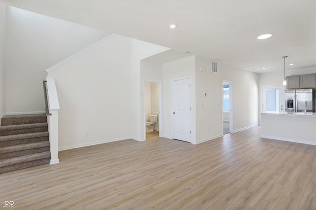 unfurnished living room with light wood-type flooring and sink