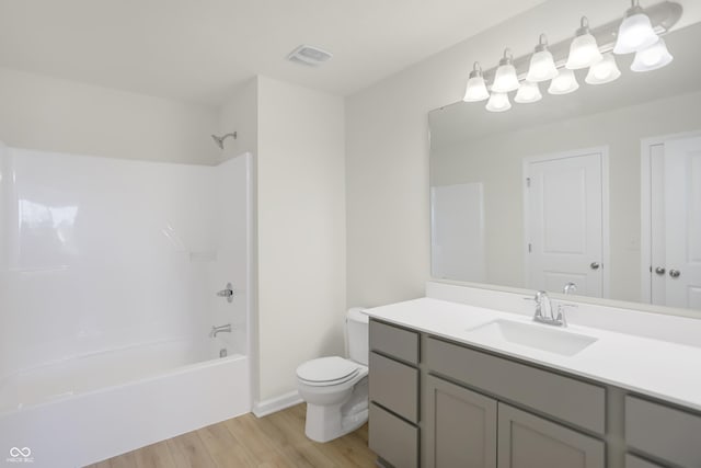 full bathroom featuring vanity, washtub / shower combination, wood-type flooring, and toilet