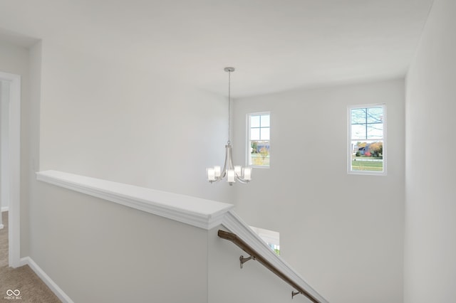 staircase with carpet and a notable chandelier