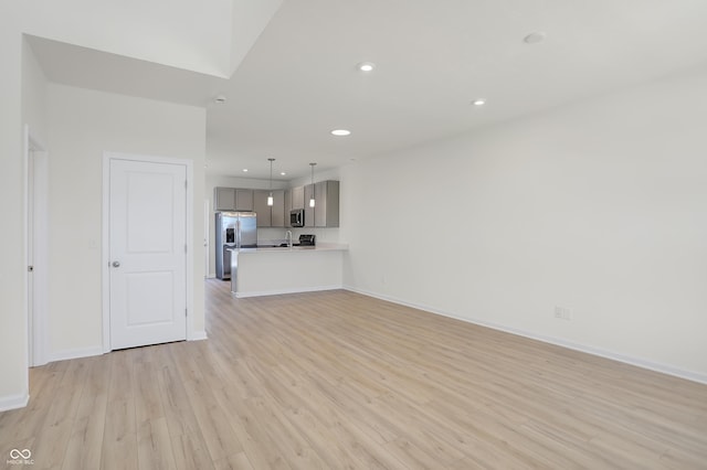 unfurnished living room with sink and light wood-type flooring