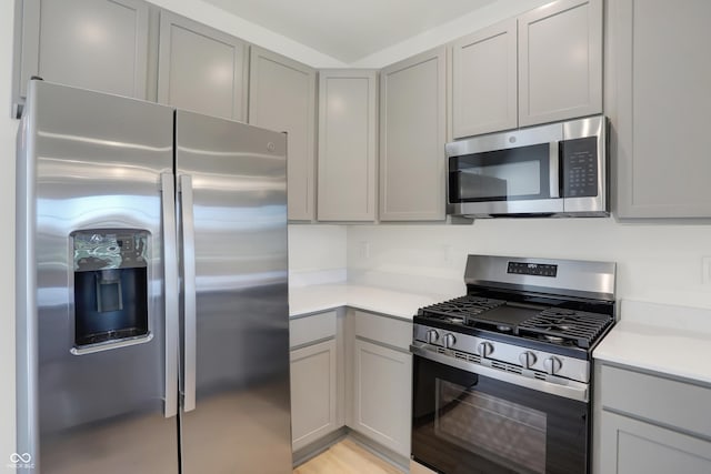 kitchen with gray cabinetry and appliances with stainless steel finishes