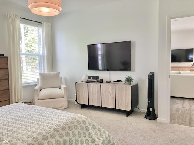 bedroom with baseboards and light colored carpet