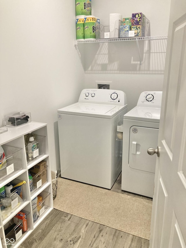 laundry area featuring laundry area, washer and clothes dryer, and wood finished floors