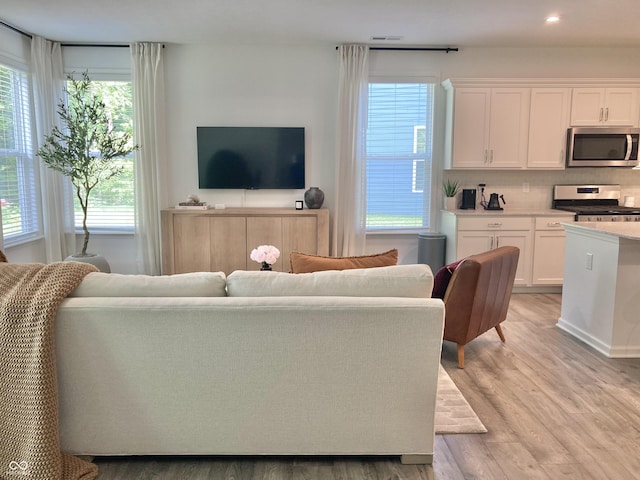 living area with recessed lighting and light wood-style floors