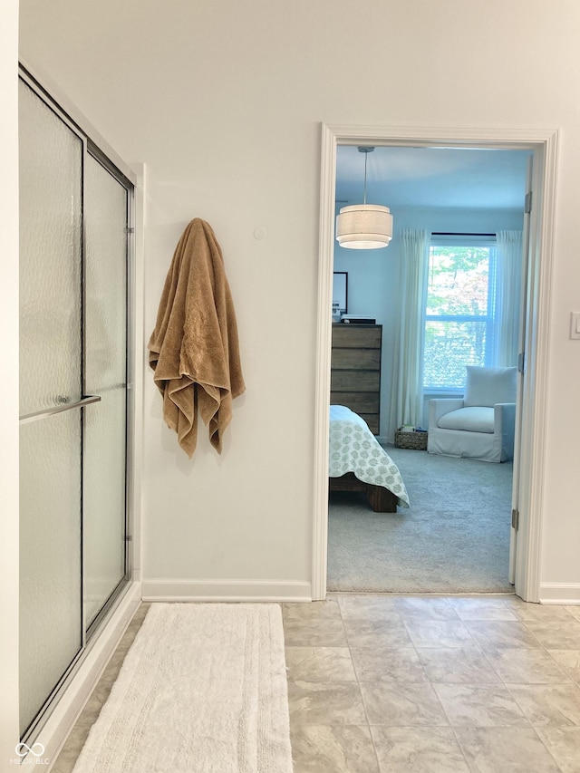 ensuite bathroom with ensuite bath, an enclosed shower, and baseboards