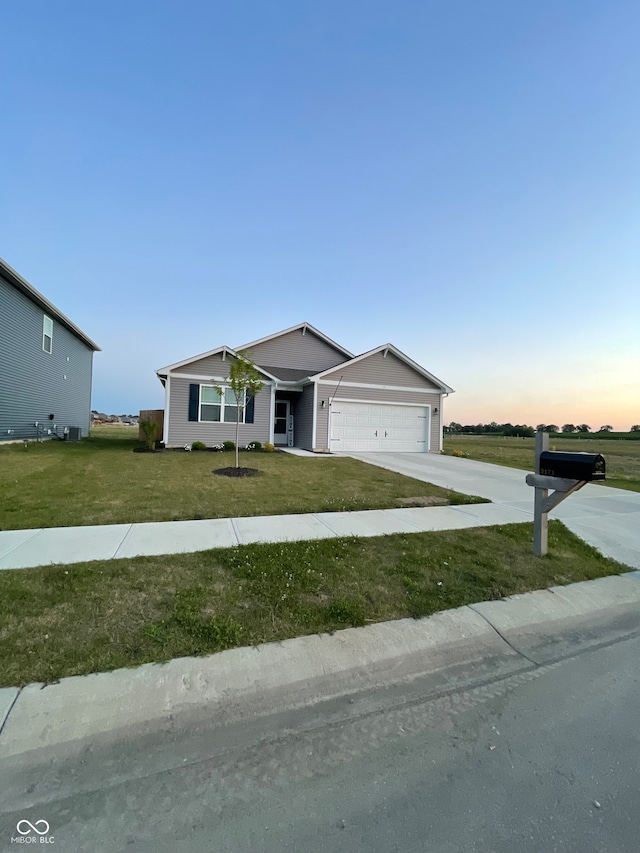 ranch-style house with a garage and a yard