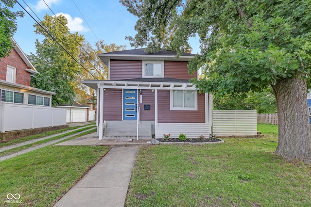 view of front of house featuring a garage, a front yard, and an outdoor structure