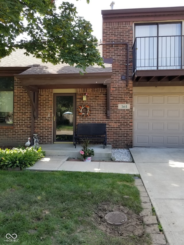 property entrance with a lawn and a garage