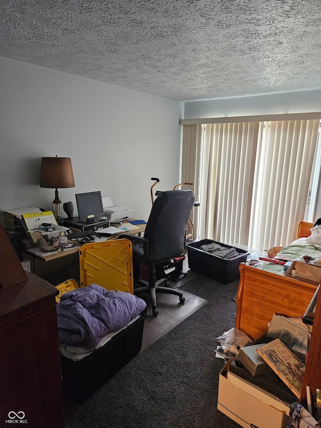 carpeted home office featuring a textured ceiling