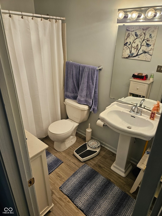 bathroom featuring hardwood / wood-style floors, toilet, and walk in shower