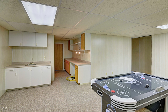 playroom with a paneled ceiling, sink, and light carpet