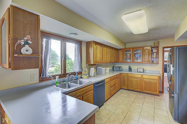 kitchen with black dishwasher, a textured ceiling, light tile patterned flooring, sink, and stainless steel refrigerator