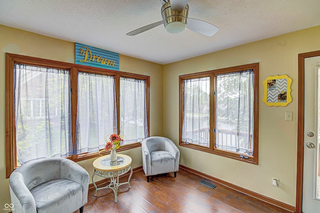 sitting room featuring ceiling fan, a textured ceiling, and hardwood / wood-style flooring