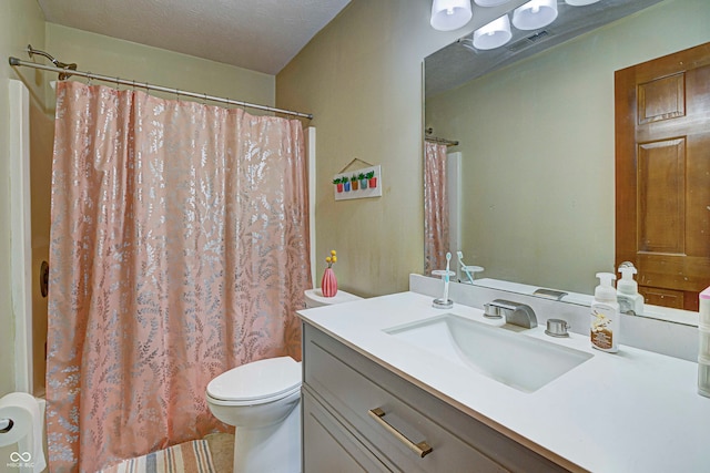 bathroom with a textured ceiling, vanity, and toilet