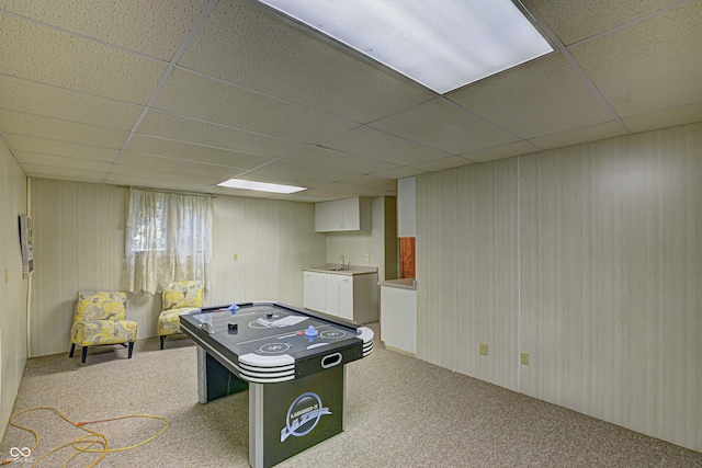 recreation room with sink, a drop ceiling, and carpet floors