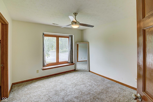 unfurnished room featuring ceiling fan, a textured ceiling, and carpet floors