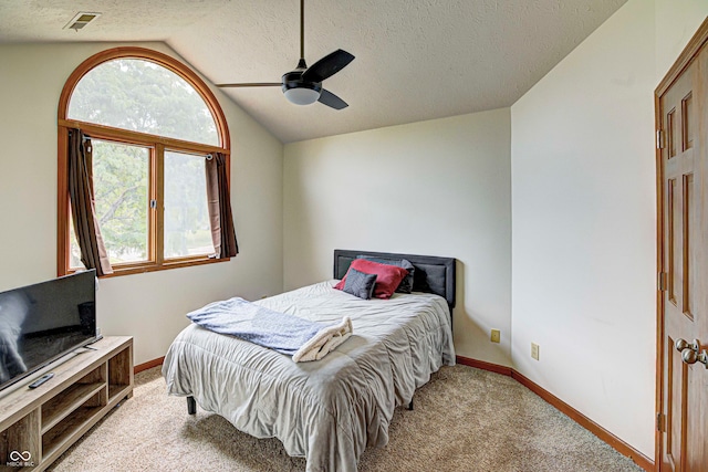 carpeted bedroom with lofted ceiling, a textured ceiling, and ceiling fan