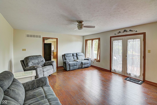 living room with ceiling fan, wood-type flooring, french doors, and a textured ceiling