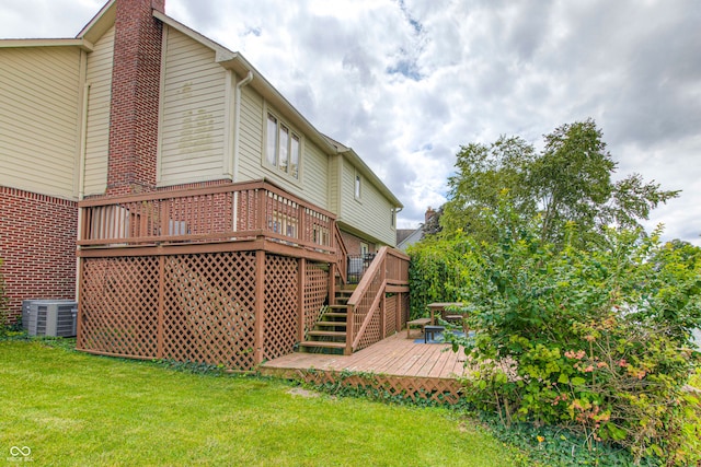 back of property featuring a wooden deck, central AC unit, and a yard