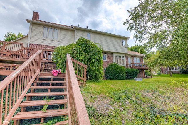 back of property with a deck and a lawn