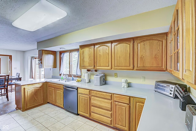 kitchen featuring dishwasher, a textured ceiling, and kitchen peninsula