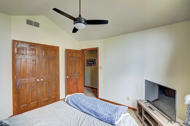 bedroom with ceiling fan, carpet floors, a closet, and lofted ceiling