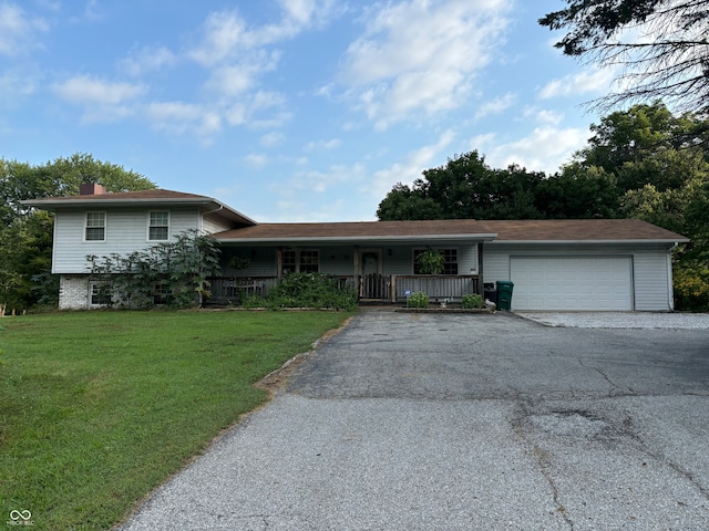 view of front of house with a garage, a front yard, and covered porch