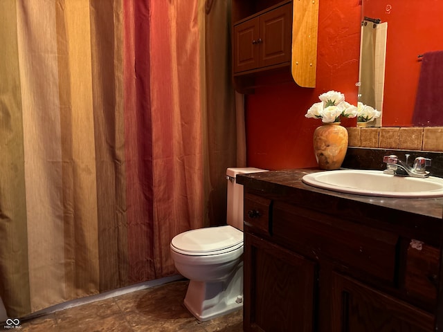 bathroom featuring tile patterned flooring, toilet, decorative backsplash, and vanity