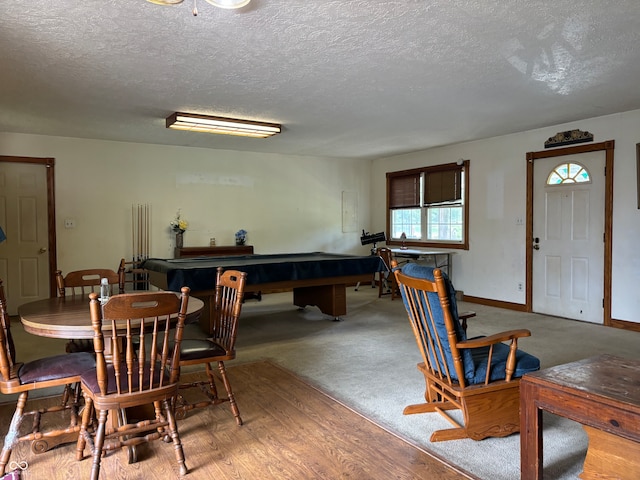 dining space with a textured ceiling, pool table, and hardwood / wood-style floors