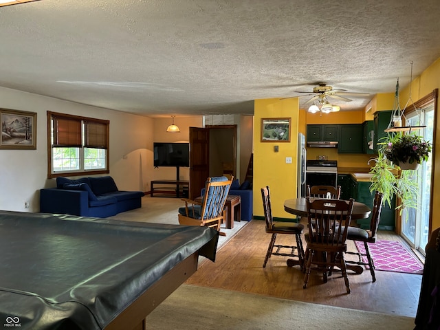 rec room featuring light hardwood / wood-style floors, pool table, a textured ceiling, and ceiling fan