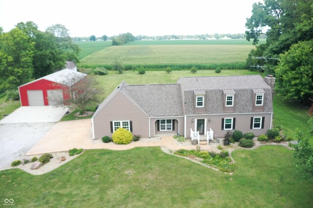 cape cod house with a front yard, a garage, and an outbuilding