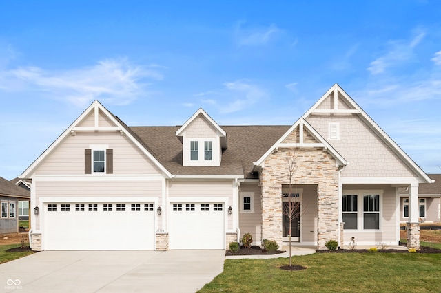 craftsman house featuring a garage and a front lawn