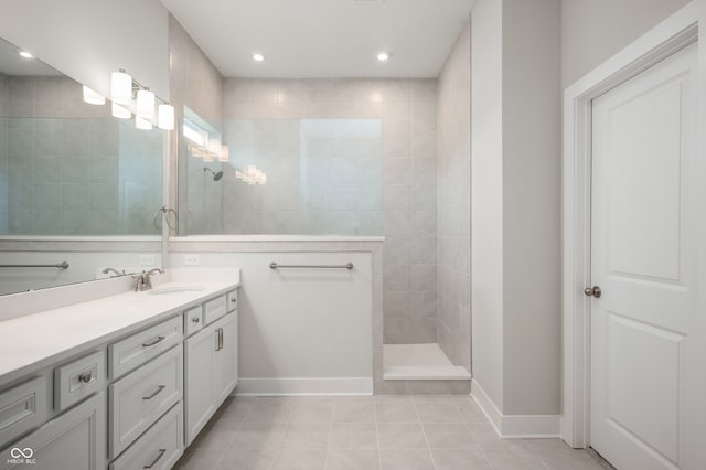 bathroom with tile patterned floors, vanity, and tiled shower