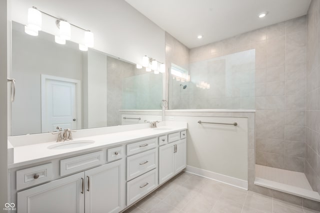 bathroom featuring a tile shower, tile patterned floors, and vanity