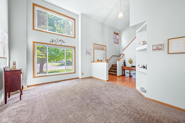 carpeted entryway with a high ceiling